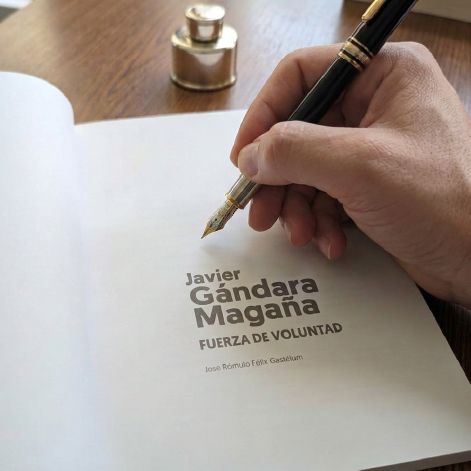 Javier Gándara Magaña firmando un ejemplar del libro